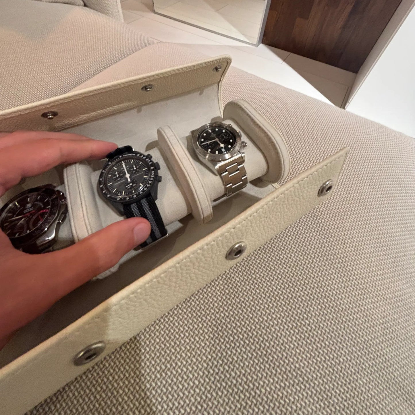 UHRENROLLE ATELIER in Creme mit drei Armbanduhren bei der Entnahme einer Uhr