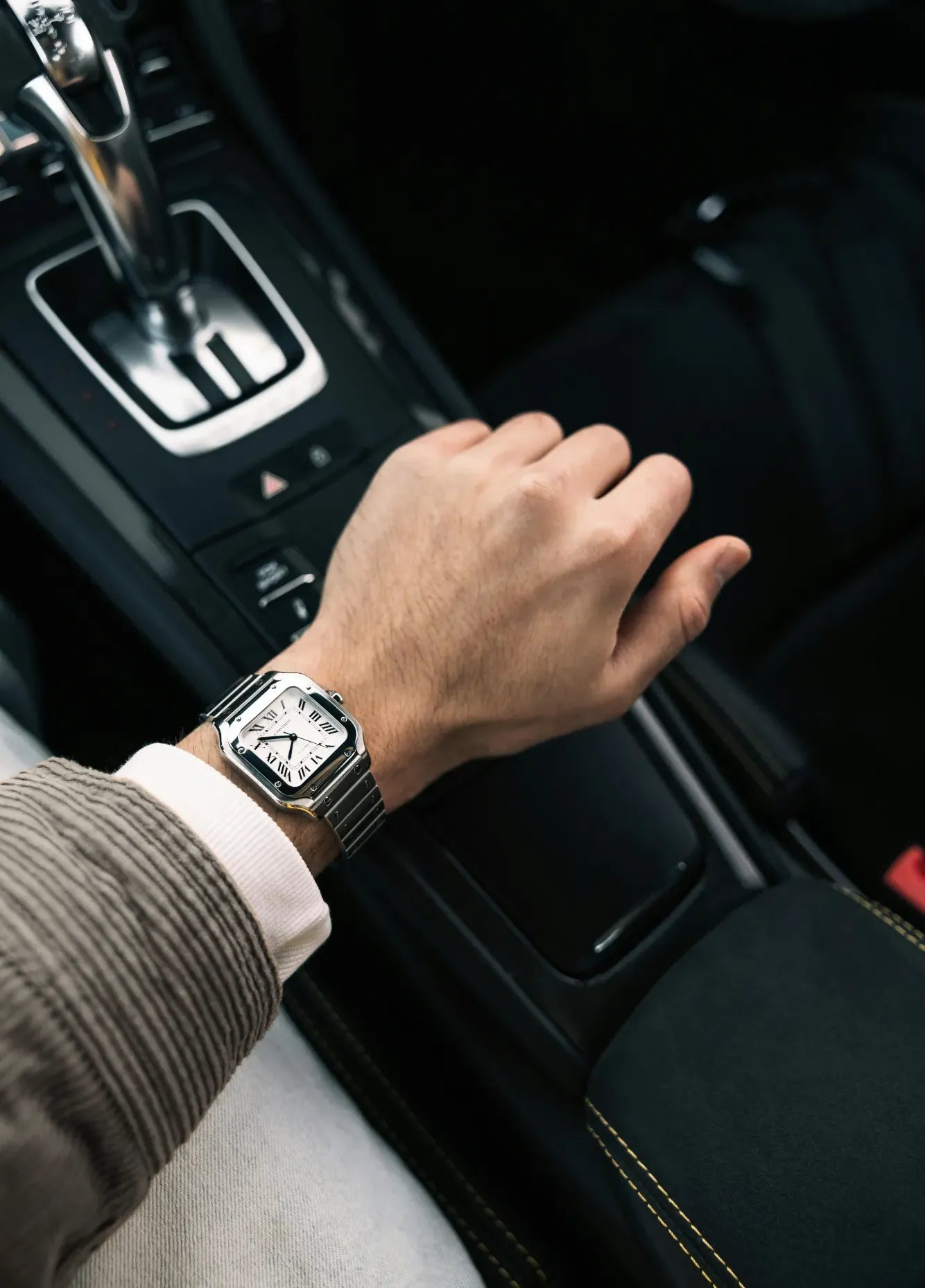 Eleganter Mann mit Cartier Uhr genießt den Moment im Sportwagen – uhrenrolle