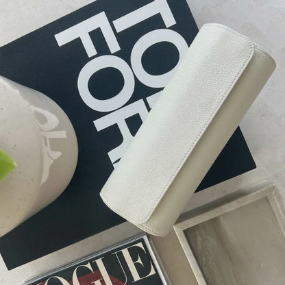 Cremeweiße Leder-Uhrenrolle aus der Atelier-Kollektion auf Marmoroberfläche, dezente Lichtbewegung