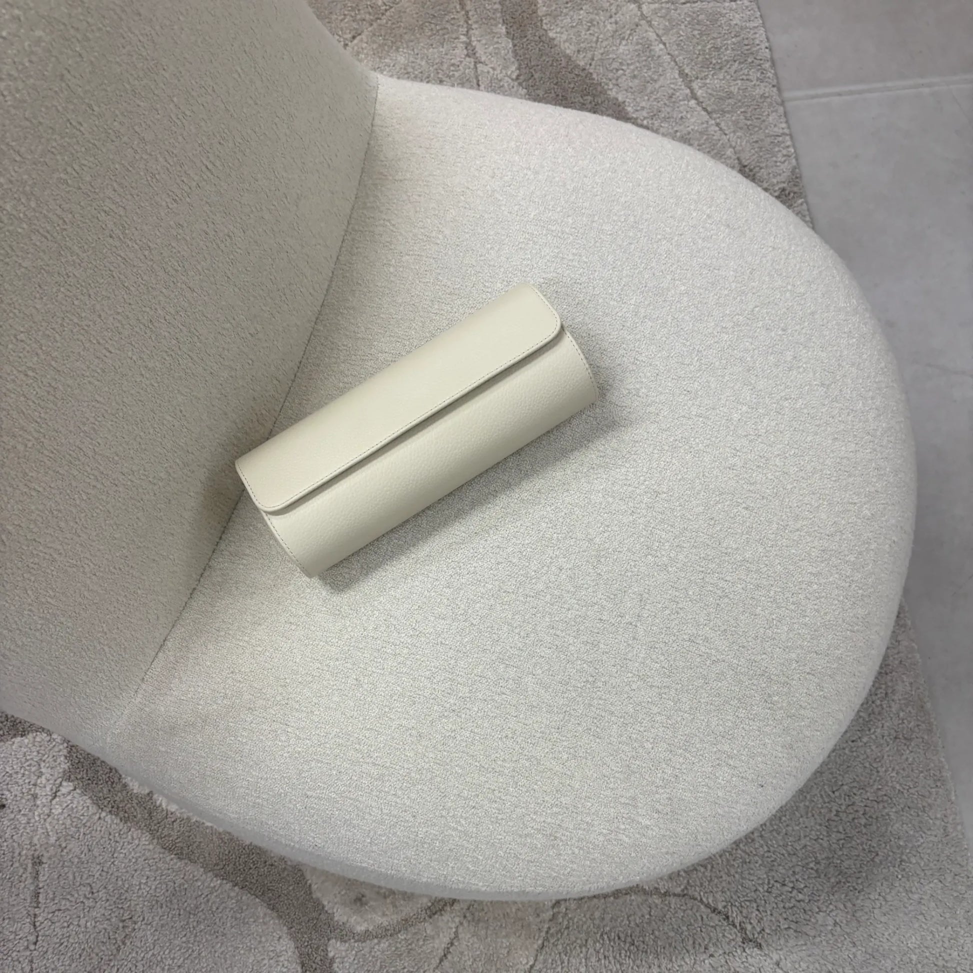 Uhrenrolle ATELIER stilvoll auf einem hellen Sessel platziert