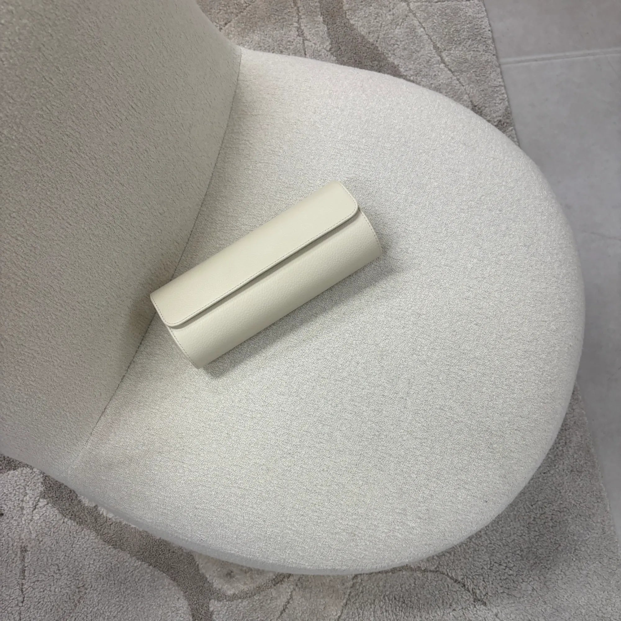 Uhrenrolle ATELIER stilvoll auf einem hellen Sessel platziert